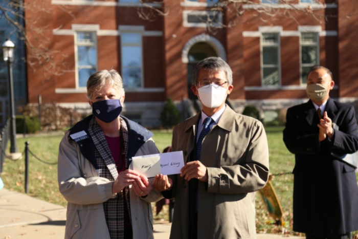 two people pose with an envelope