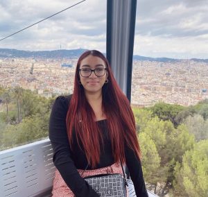 Noelia rides in a cablecar overlooking a city in Spain.