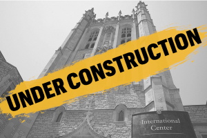 The Memorial Union tower in black and white with "under construction" in black and gold over it.