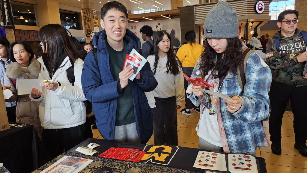 Students look at the Lunar New Year informational display on a table in the MU Student Center.