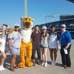 Two students and two instructors pose with MU's Truman the Tiger mascot and two MU cheerleaders at the Royal's baseball stadium.