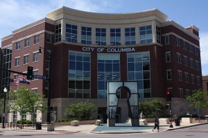 Columbia City Hall, a five story brick building with a key-hole shaped sculpture out front.